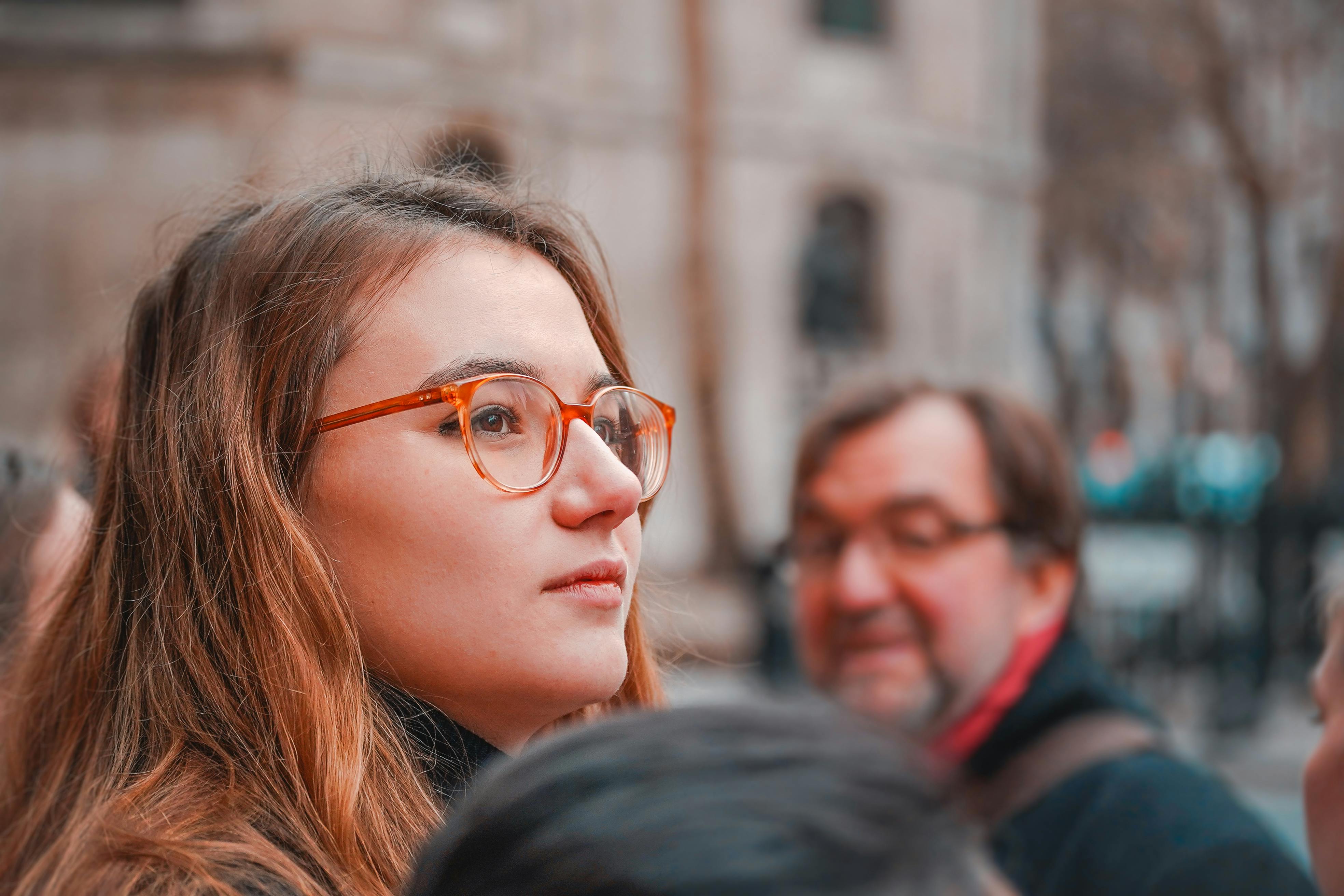 Close-up of a young woman with glasses looking away, captured outdoors in London.