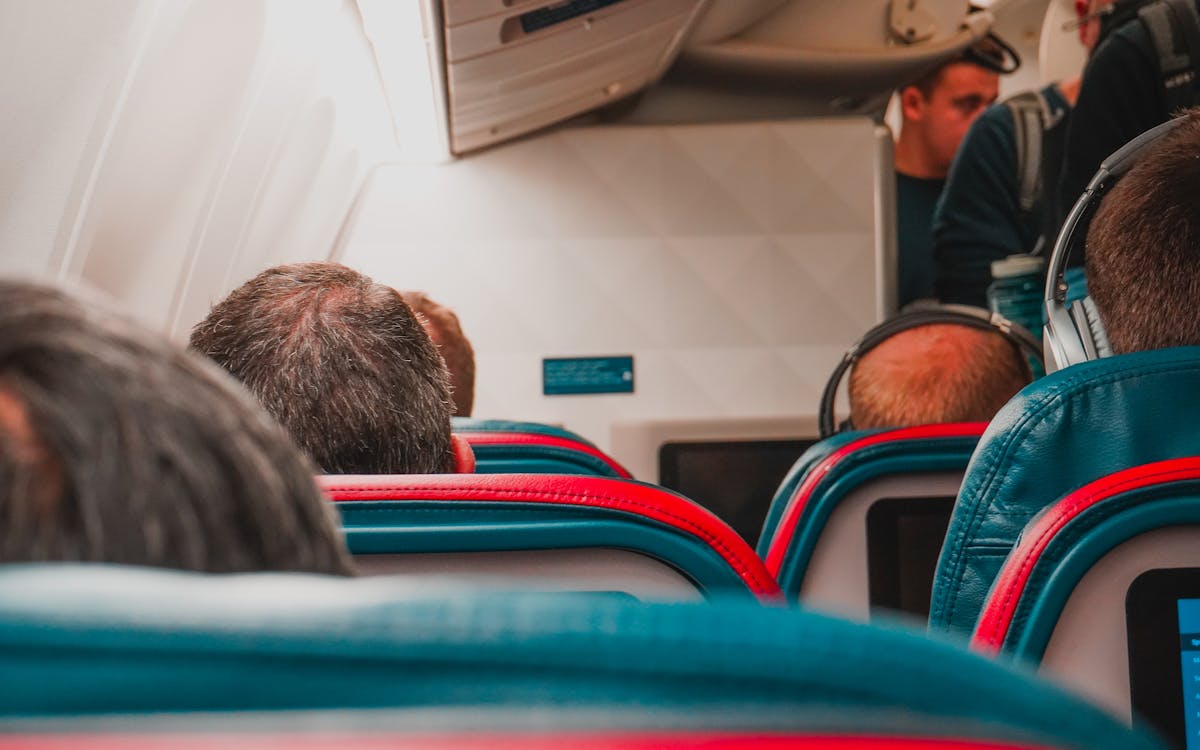 Interior view of an airplane cabin with passengers seated, focusing on seats and layout.