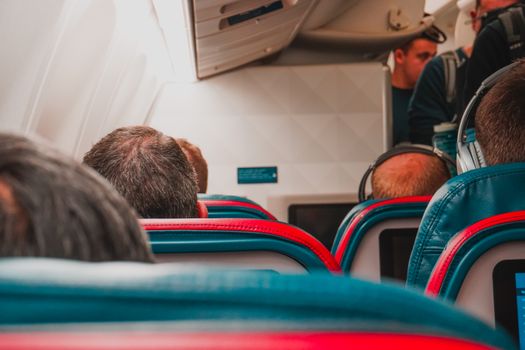 Interior view of an airplane cabin with passengers seated, focusing on seats and layout.