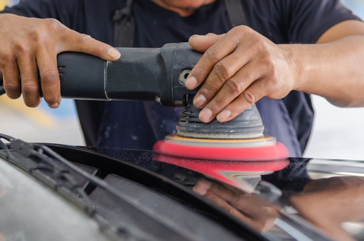 Person Holding A Black Polishing Machine