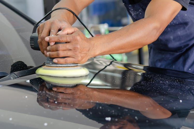 A Person Buffing A Car