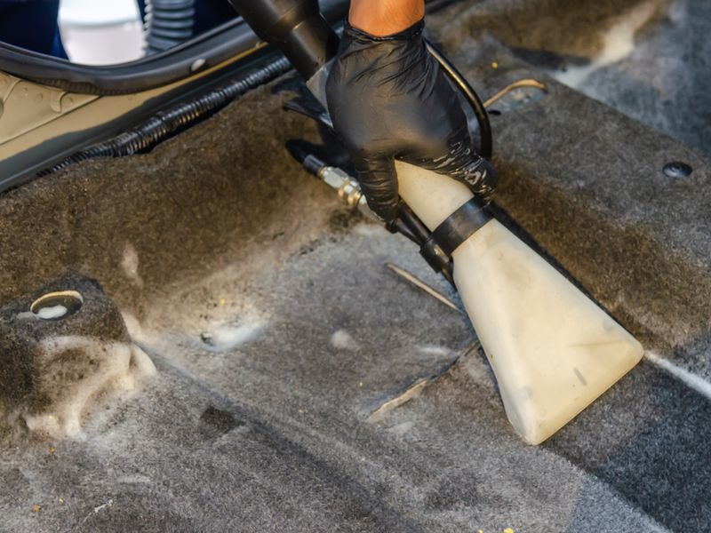 Deep vacuuming a car carpet to lift embedded dirt