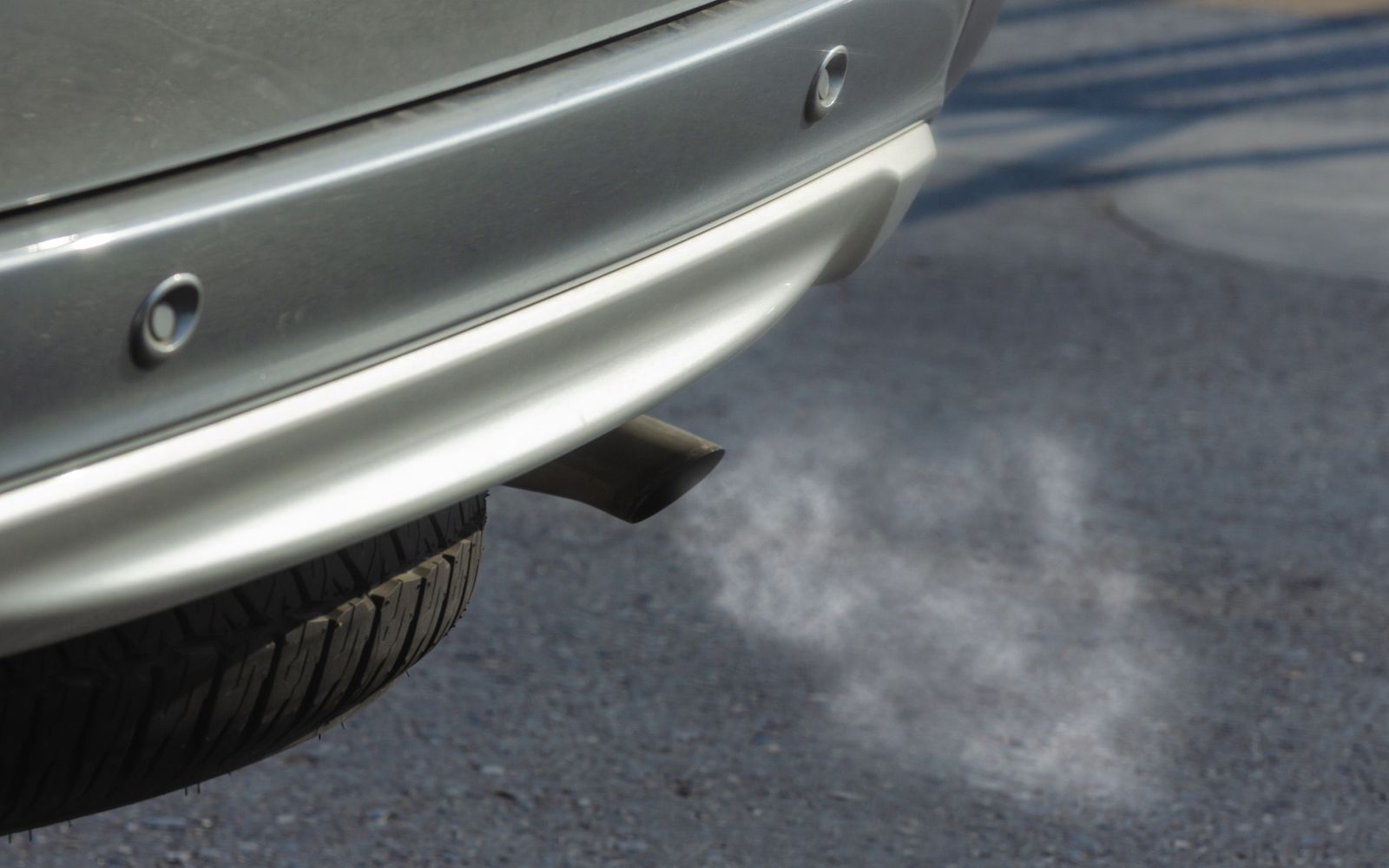 Close-up of a vehicle exhaust pipe emitting smoke