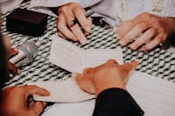 Hands Holding a Pen and Papers