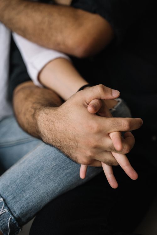 Free Close-up of a couple holding hands, symbolizing love and affection. Stock Photo