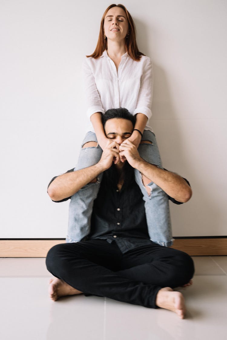 Man Sitting On The Ground Kissing The Woman's Hand