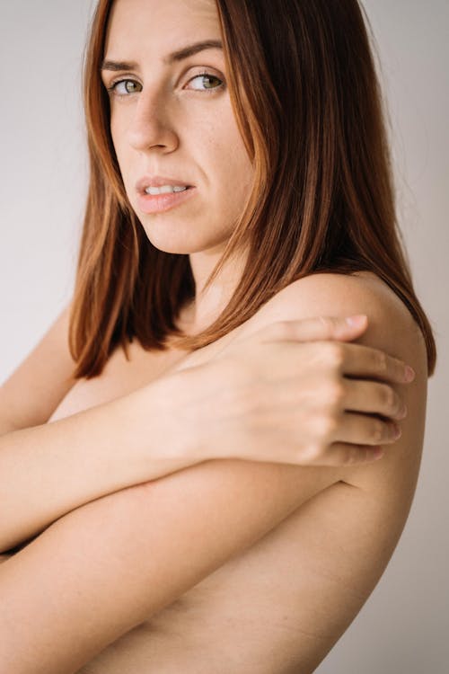 Topless Female Posing with her Hand on her Shoulder