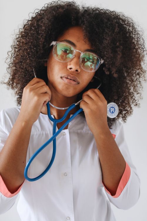 Free A focused female doctor adjusting her stethoscope, conveying professionalism. Stock Photo