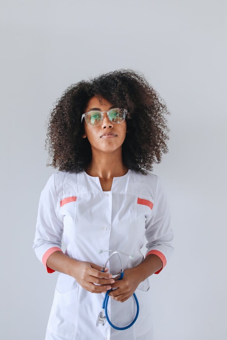 Curly Haired Woman Standing Holding Blue Stethoscope