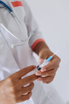 Close-up of medical professional holding and preparing a syringe for injection.