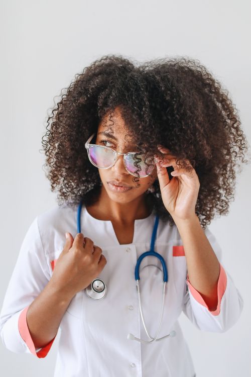 Free Close-up of a female doctor adjusting her glasses, exuding confidence and professionalism. Stock Photo