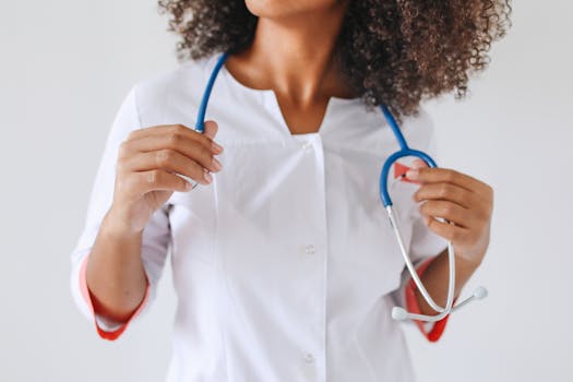 A female doctor holds a stethoscope, focusing on healthcare professionalism.