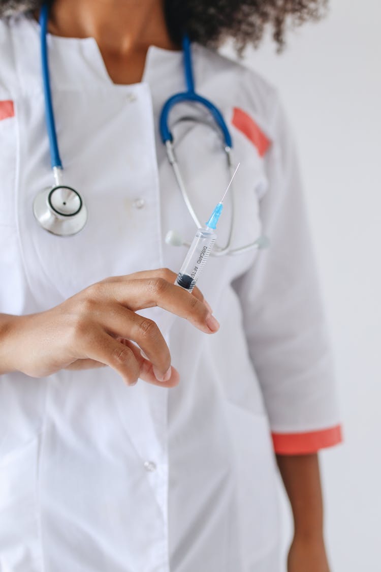 A Woman's Hand Holding A Syringe