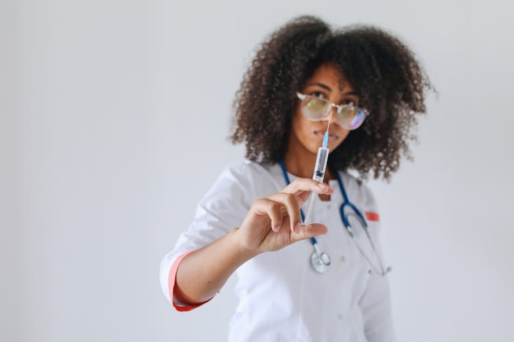 Woman Pushing The Plunger Of A Syringe