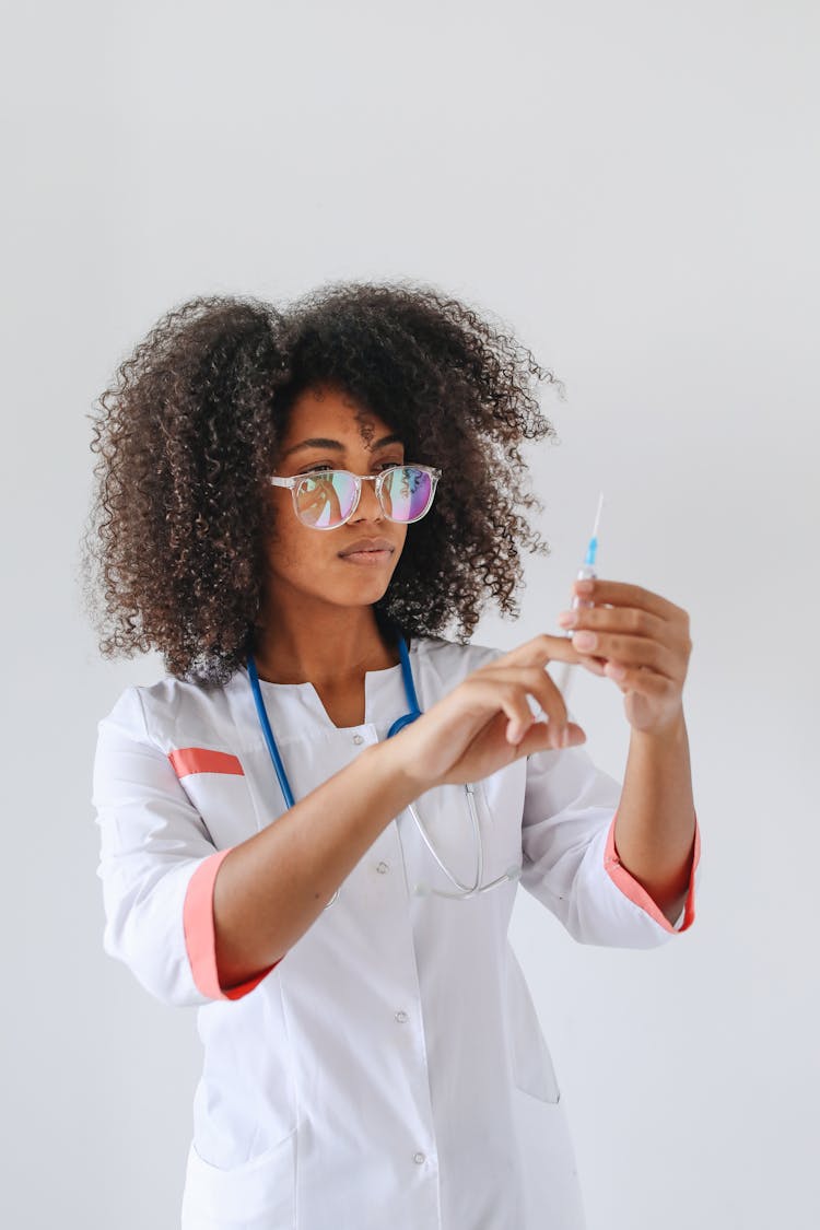 Woman In White Button Up Dress Looking At The Syringe