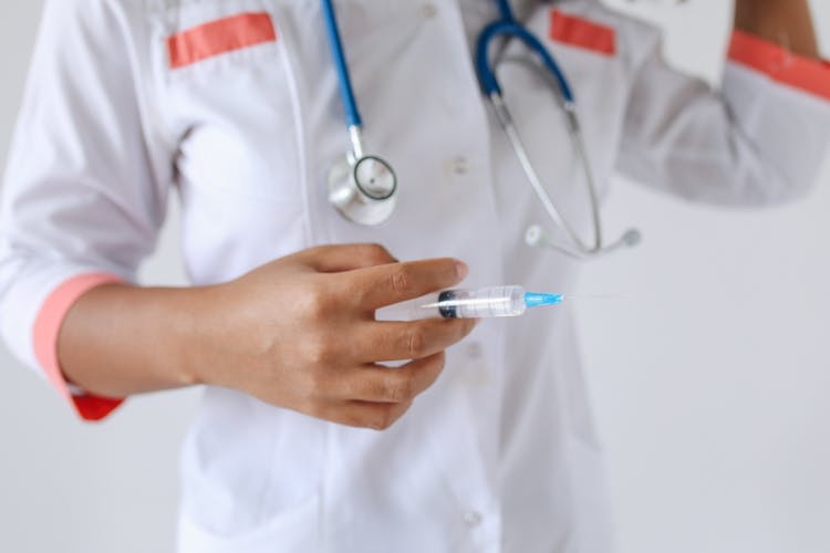 Hand Holding A Syringe With Liquid