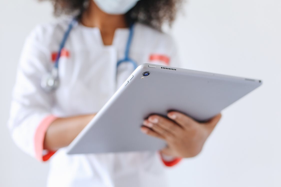 Free Person Wearing a Face Mask Holding an Ipad Stock Photo