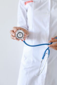 一位穿着白大褂的医疗专业人员手持听诊器，凸显了医疗保健和医学的主题