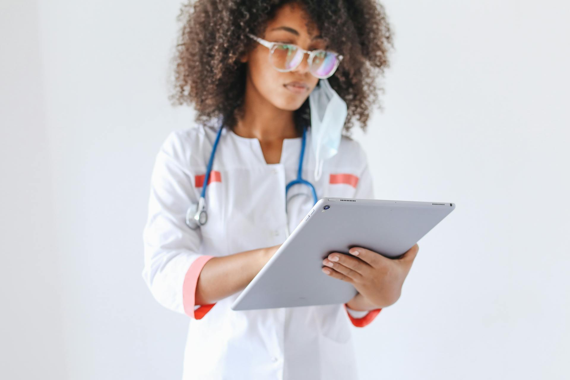 A female doctor using a digital tablet, symbolizing modern healthcare and technology integration.