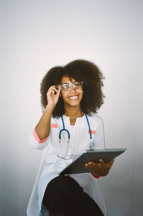 Free Happy female doctor with stethoscope and tablet, looking confident and approachable. Stock Photo