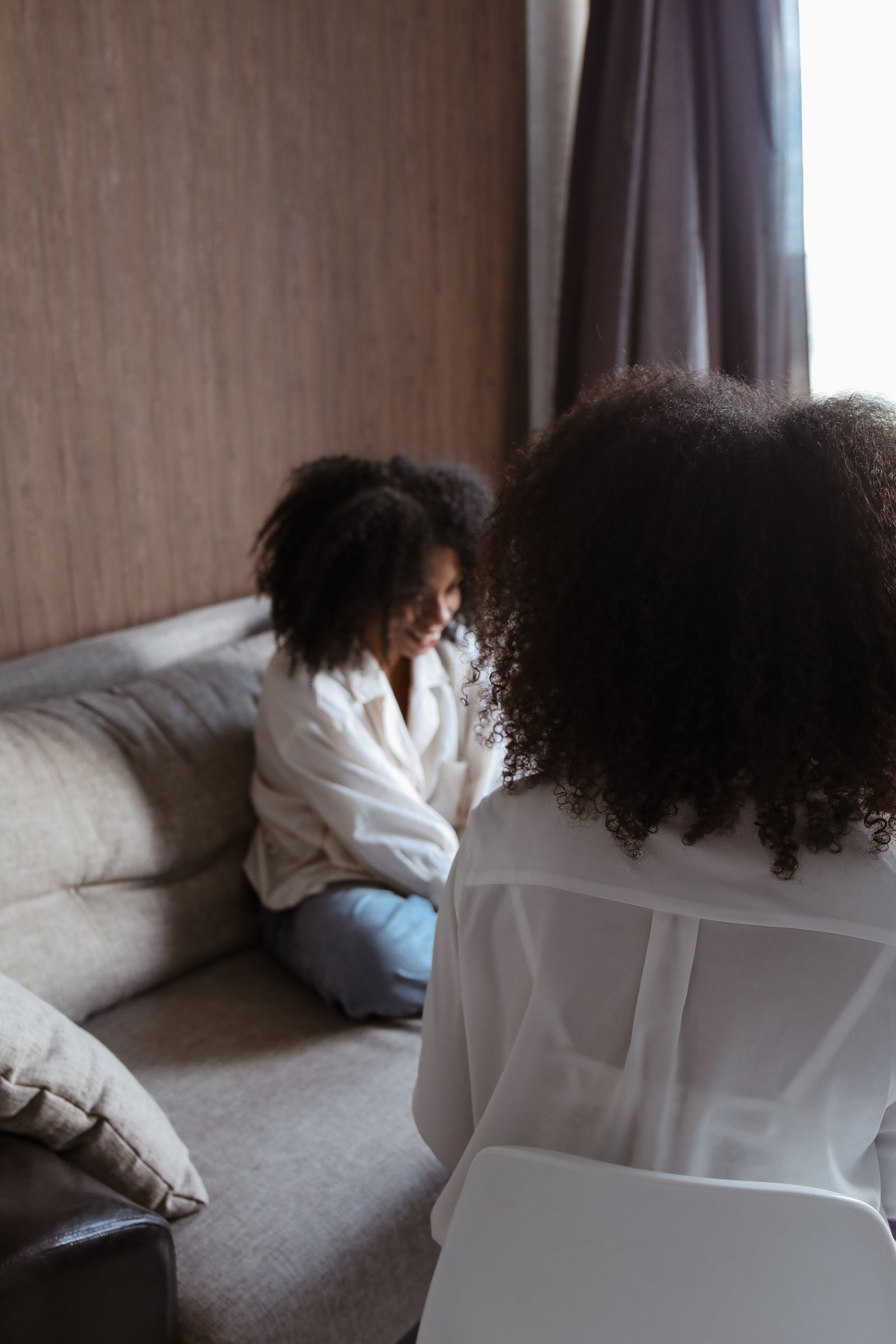Two people in a quiet, supportive conversation in warm natural light