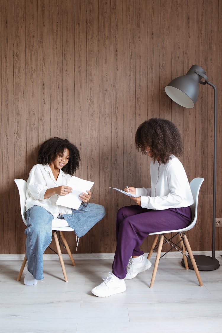 Women Sitting Looking At Documents