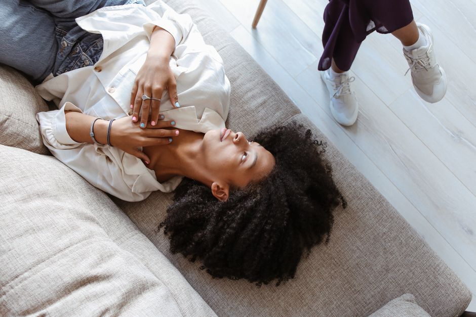 Woman with afro hair lying on a couch during a casual indoor session.