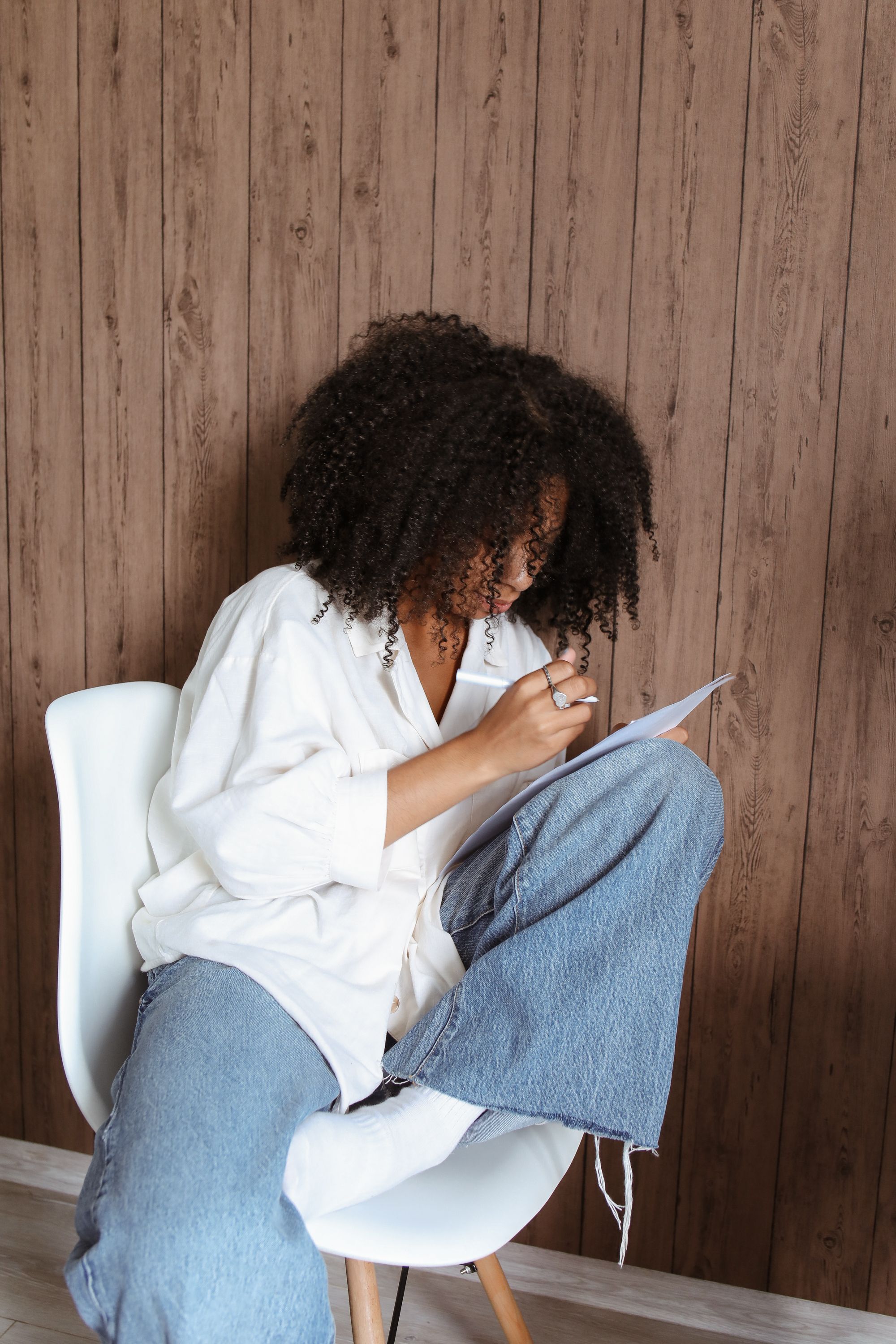A Woman in White Long Sleeves and Denim Jeans Sitting on the Chair ...