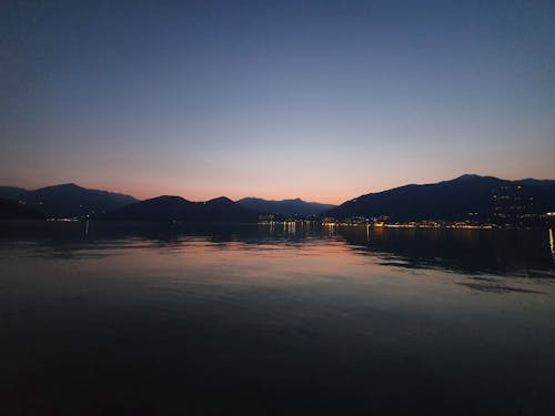 Silhouette of Mountains and a Lake During Sunset