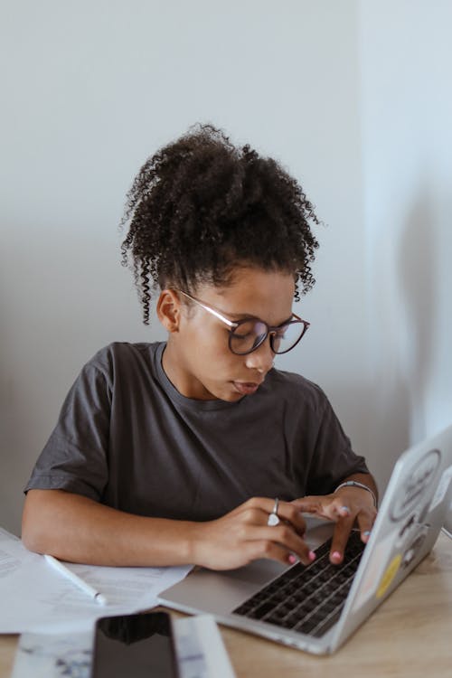 Teenage Girl in Gray Shirt Using a Computer Laptop