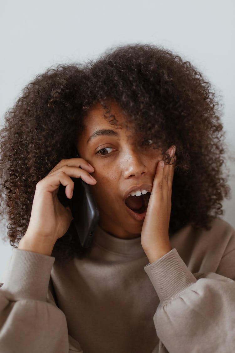 Portrait Of Surprised Woman Talking On Phone 