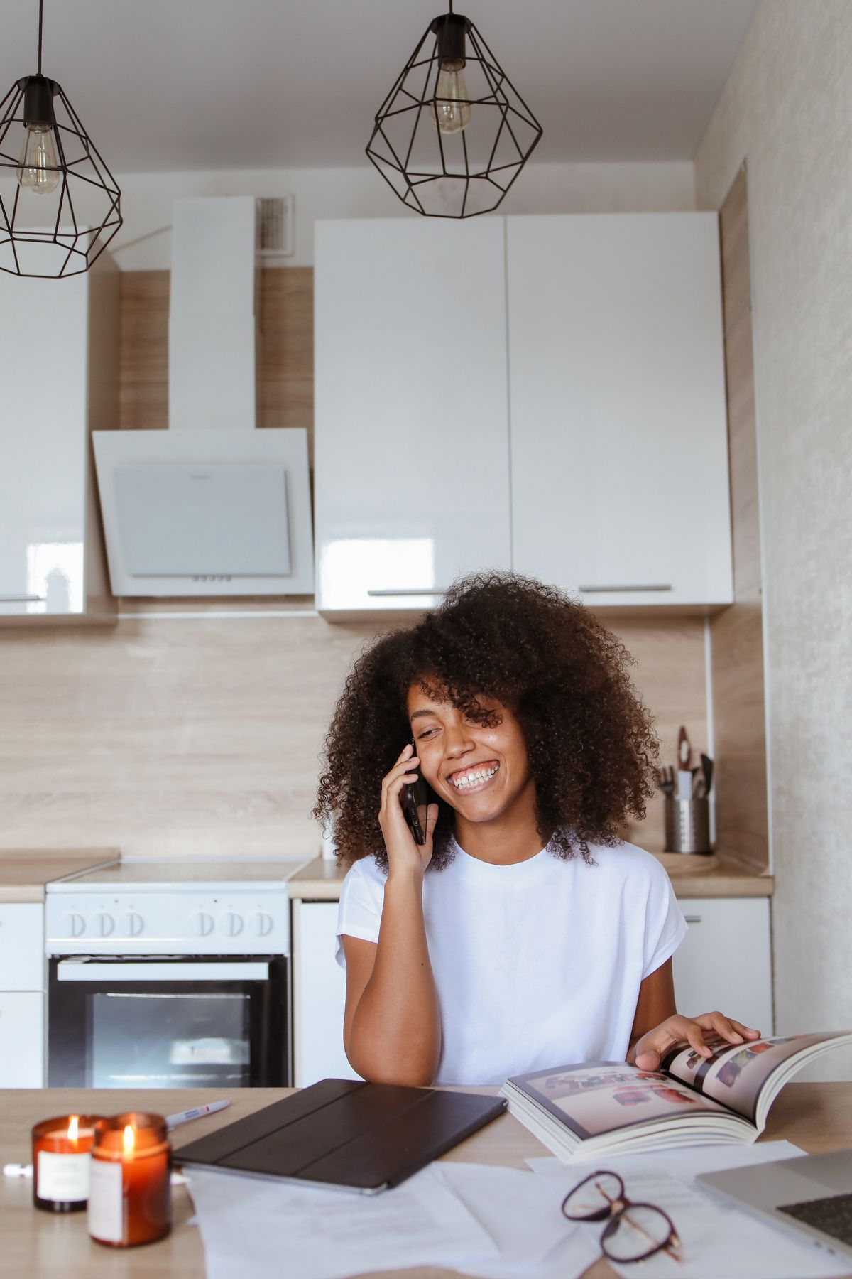 Mujer con auriculares consulta una aplicación de ayuno en su teléfono mientras toma café en la cocina
