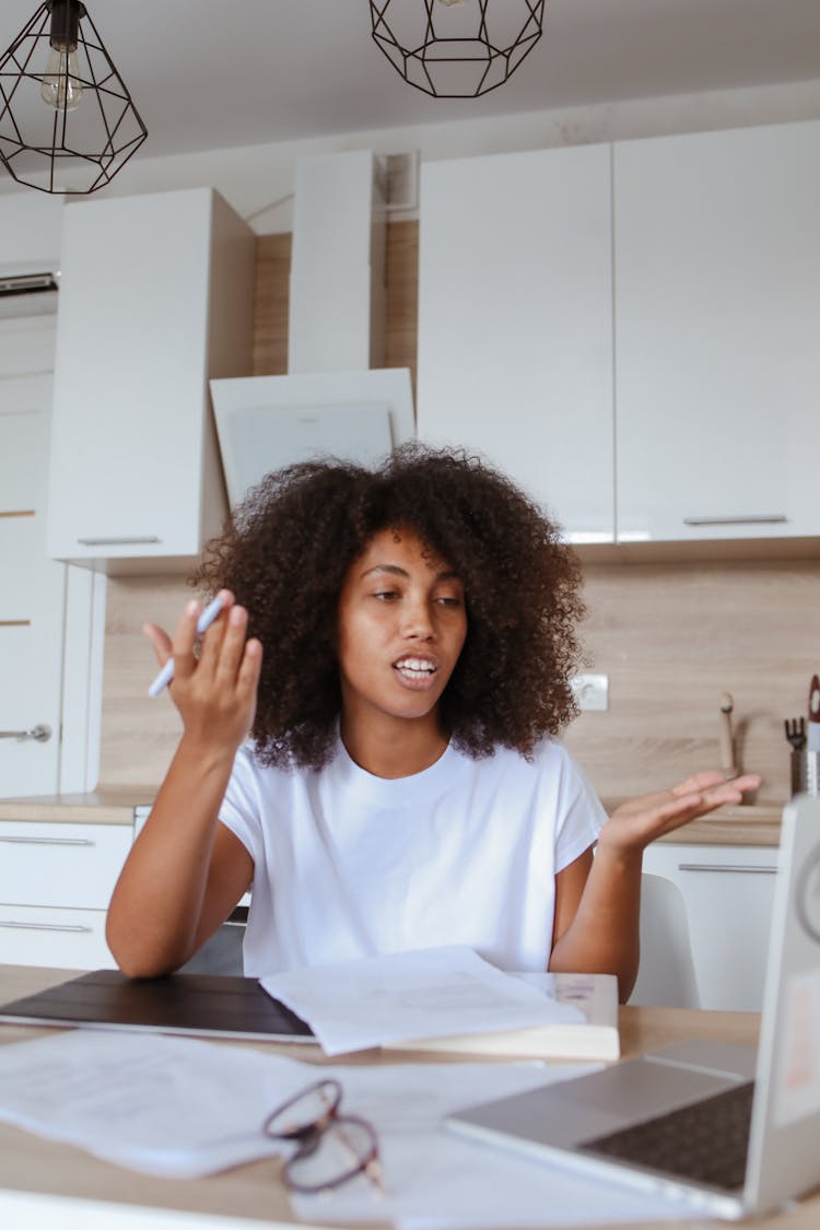 Young Woman In White Shirt Sitting And Having Video Call Conversation On Computer Laptop