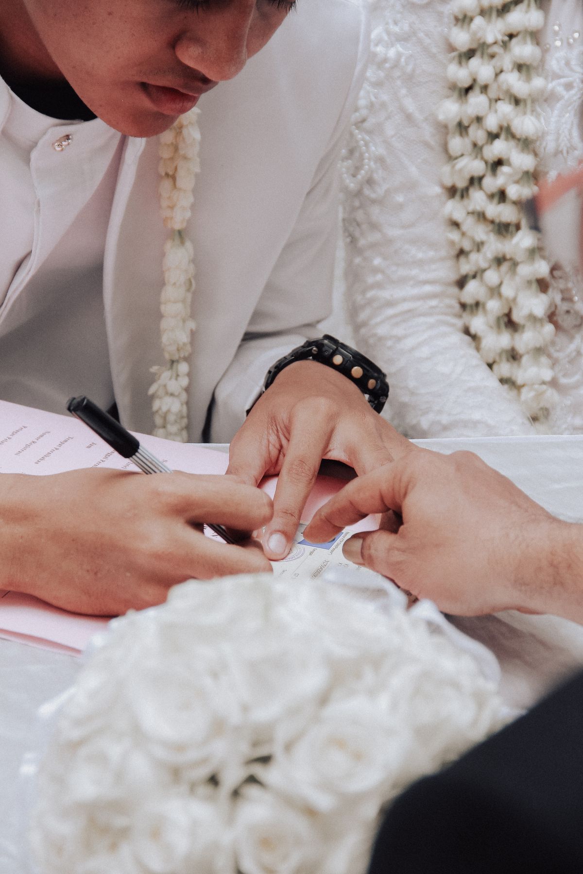 Bride and groom signing a wedding vendor contract together