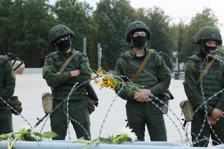 Military Men Guarding A Wired Post