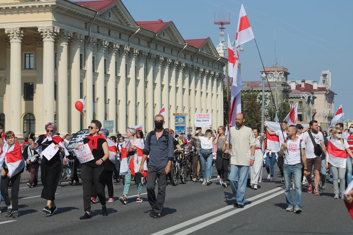 Free Protesters Walking Together Carrying Flags and Banners Stock Photo