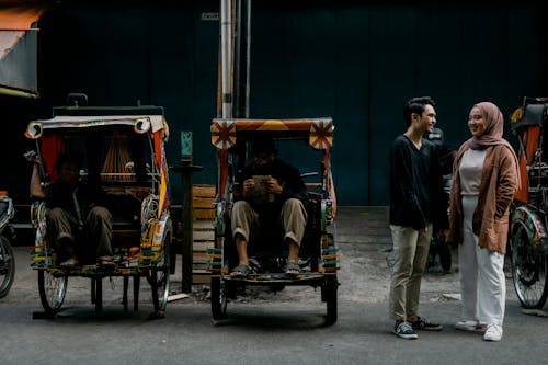 Couple Standing Beside Rickshaws on the Streets