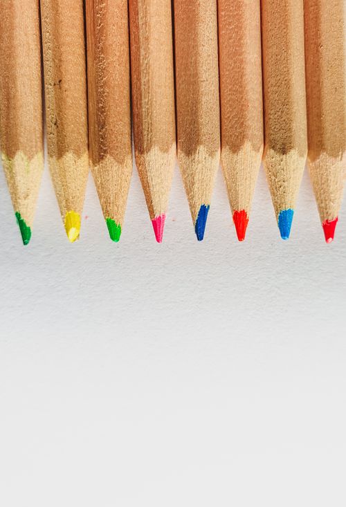 Free Close-up of colorful pencil tips aligned in a neat vertical row on a white surface. Stock Photo