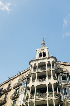 Low angle view of a historical building in Barcelona with elaborate balconies and clear sky.