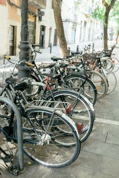 阳光明媚的街道上停着多辆自行车，凸显了城市通勤的生活方式