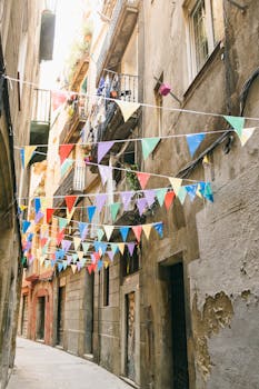 Colorful banners hang in a narrow alleyway, creating a festive atmosphere.