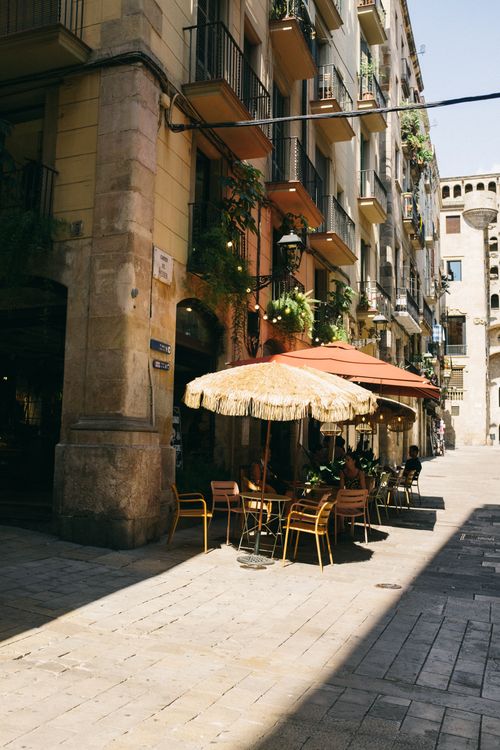 Free Cozy outdoor café along a sunny street in a bustling Mediterranean city. Stock Photo