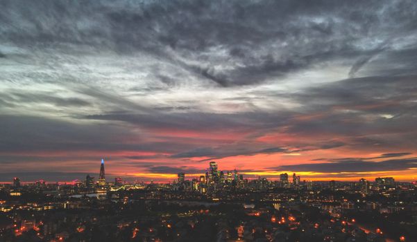 Stunning aerial view of London skyline under vibrant sunset clouds.