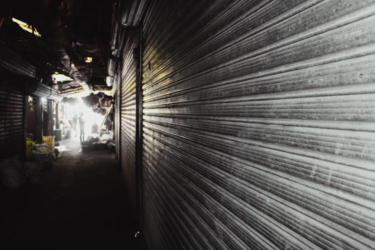 Dark Tunnel Alley In City Between Warehouses