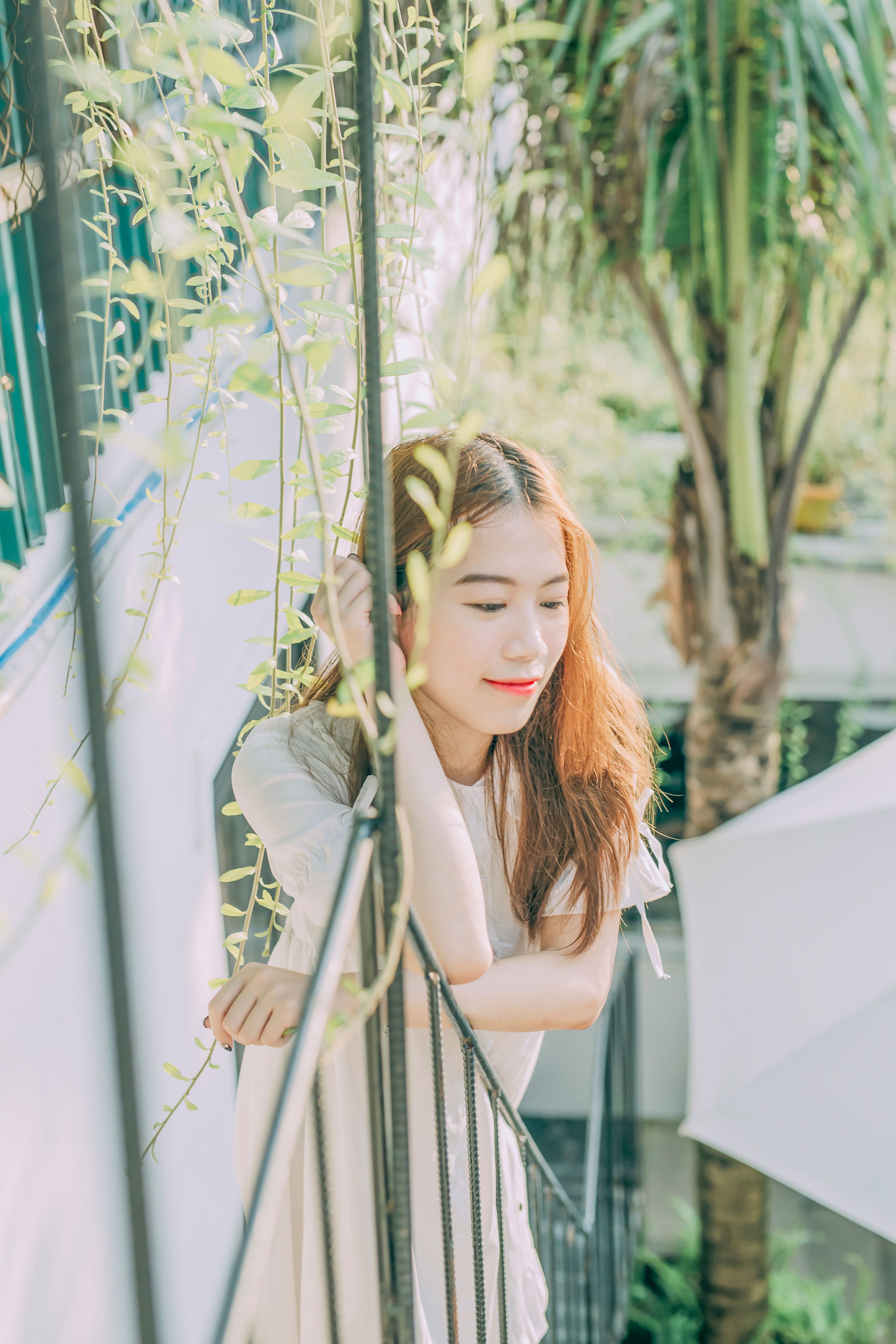 夏日阳光下，一位年轻女子在篱笆旁放松，散发着宁静与幸福