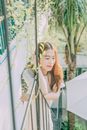 夏日阳光下，一位年轻女子在篱笆旁放松，散发着宁静与幸福