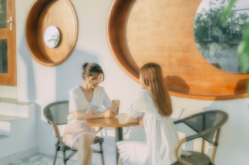 Free Ladies meeting in modern cafe in sunlight Stock Photo