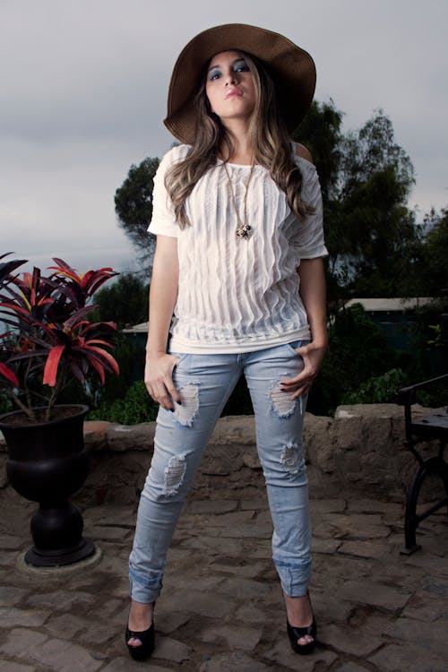 A Woman Wearing a White Shirt Standing With Her Hand on Her Pockets