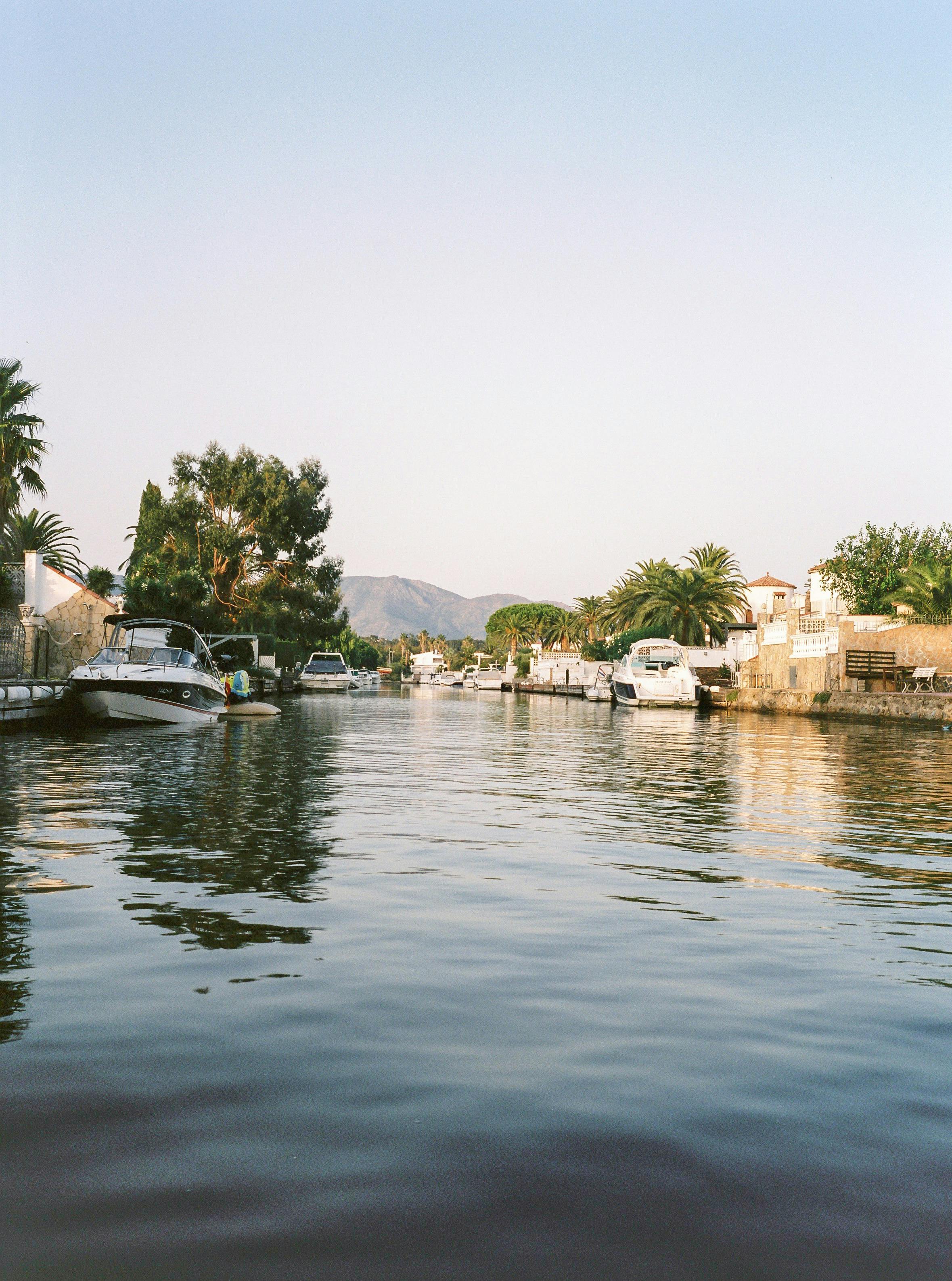 日出时分，宁静的运河、停靠的船只与晴朗的天空构成了一幅美景