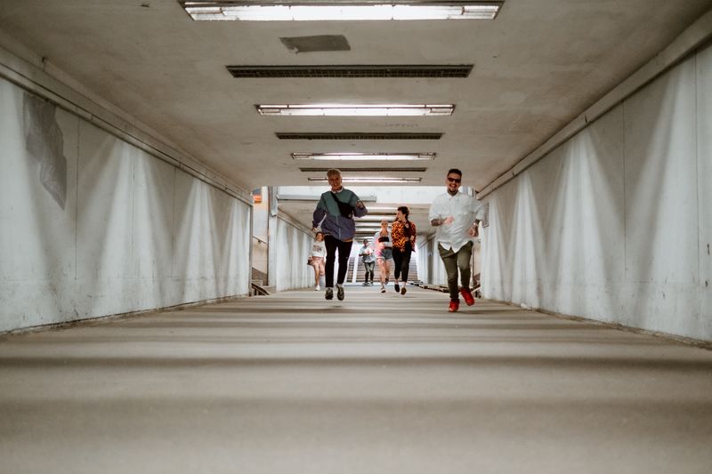 Three runners moving together through a concrete underpass, photo by cottonbro studio on Pexels